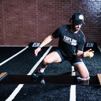 A hockey goalie trains using the Brrrn Board and a tennis ball.